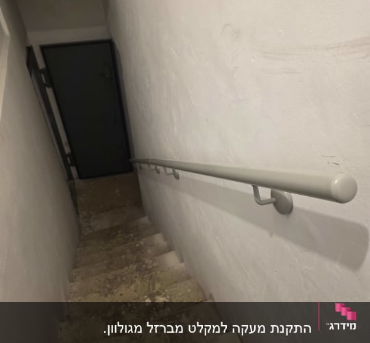 מדרגות עם מעקה מתכת ליד קיר לבן
